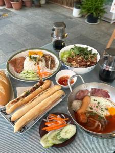 a table topped with plates of food and bowls of food at Homer House Hostel & Café in Vientiane