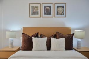 a bedroom with a bed with three pictures on the wall at Empire Home! in Praia