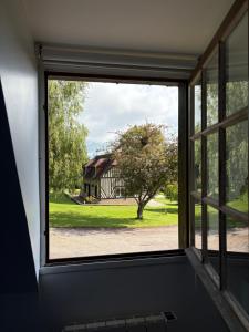 an open window looking out at a house at Le Cottage in Cambremer +4 photos