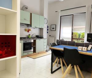 a kitchen and living room with a table and chairs at The Water Lodge in Omegna