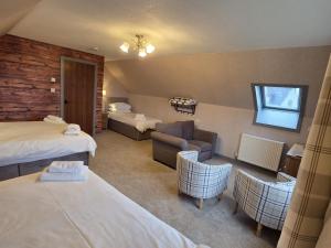 a hotel room with two beds and a couch at Sanderlay Guest House in Kirkwall +15 photos