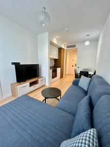 a living room with a blue couch and a television at NovaStay Apartments in Batumi