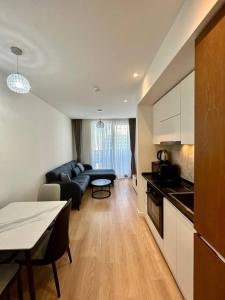a kitchen and living room with a couch and a table at NovaStay Apartments in Batumi