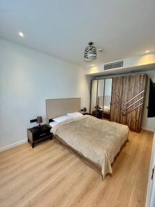 a bedroom with a large bed and a wooden floor at NovaStay Apartments in Batumi +31 photos