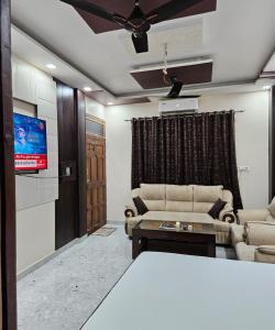 a living room with a couch and a tv at The Hotel Siddhi Residency near Ram Mandir in Ayodhya