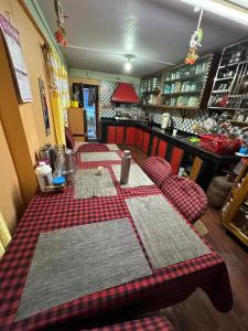 a restaurant with two tables with red and white checked tables sidx sidx sidx at Y Not Sonada in Sonāda