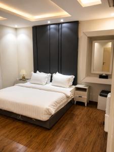 a bedroom with a large bed with a large headboard at الفرسان للشقق المخدومه in Al Kharj