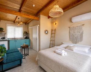 a bedroom with a large bed and a kitchen at בריאה אירוח בטבע in Sha'al +59 photos
