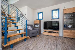 a living room with a staircase and a television at Meeresrauschen 1 in Groß Kirr