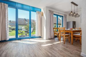 a dining room with a table and chairs and a large window at Meeresrauschen 1 in Groß Kirr