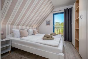 a white bed in a room with a window at Meeresrauschen 1 in Groß Kirr