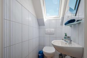 a white bathroom with a sink and a toilet at Meeresrauschen 1 in Groß Kirr +32 photos