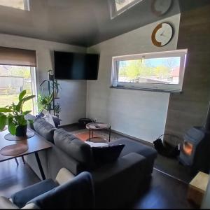 a living room with a couch and a clock on the wall at Celmu Nams in Ventspils