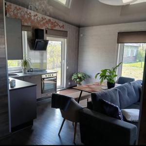 a kitchen and living room with a couch and a table at Celmu Nams in Ventspils