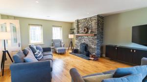 a living room with two couches and a fireplace at Winoma Lodge - Waterville in Waterville