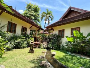 a house with a garden in front of it at Oriental Siam Resort in Chiang Mai