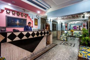 a man standing at a bar in a hotel lobby at Hotel Sunshine - Karol Bagh Budget Stay at New Delhi in New Delhi