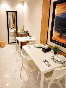 a dining room with two white tables and a sink at الفرسان للشقق المخدومه in Al Kharj