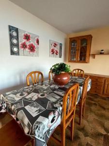 a dining room with a table with chairs and a vase on it at CHALET EN PLAYA ROBAYERA in Mogro