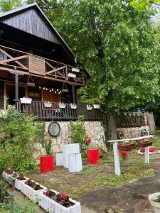 a house with red and white objects in front of it at Vikendica Lenka in Sijarinska Banja