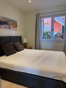 a bedroom with a large bed and two windows at Apartments Plazs 41 in Sukošan