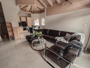a living room with a leather couch and a table at Residence Chateau in Saas-Fee