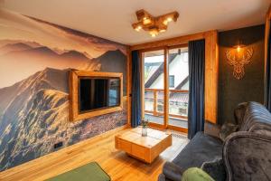 a living room with a mountain mural on the wall at Mountain Shelter Apartments in Zakopane