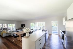 a white kitchen with a table and a couch at Martyr Views in Warburton