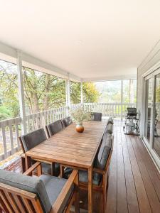 a porch with a wooden table and chairs at Martyr Views in Warburton