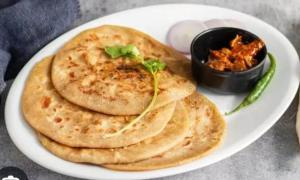 a white plate of food with pita bread and a sauce at Shivansh Homestay in Mathura