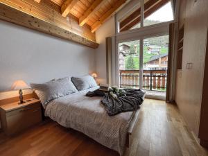 a bedroom with a bed and a large window at Residence Chateau in Saas-Fee