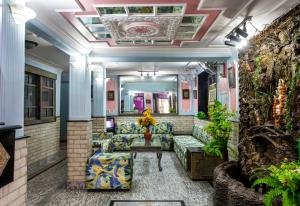 a lobby with couches and plants in a building at Hotel Sunshine in New Delhi