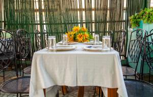 a table with a white table cloth and a vase of flowers at Hotel Sunshine - Karol Bagh Budget Stay at New Delhi in New Delhi