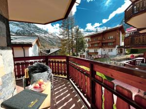 a balcony with a bowl of fruit on a table at Residence Chateau in Saas-Fee