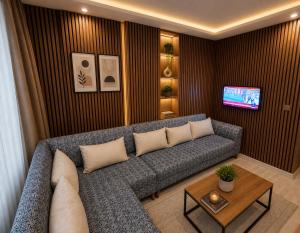 a living room with a couch and a tv at Teker Suite Hotel in Mersin
