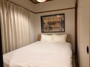 a bedroom with a bed with white sheets at 指宿 潮音 Ibusuki Shione in Ibusuki