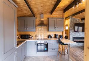 a kitchen with white cabinets and a wooden ceiling at Wildwood Haven - Killorglin in Killorglin