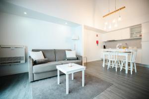 a living room and kitchen with a couch and a table at Casa das Ondas in Ribeira Grande