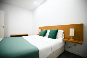 a bedroom with a large bed with green pillows at Casa das Ondas in Ribeira Grande