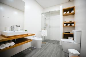a bathroom with a sink and a toilet and a shower at Casa das Ondas in Ribeira Grande +12 photos