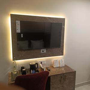 a room with a desk with a television on a wall at Leaf 9 Imperial, Subhash Nagar, Pacific Mall in New Delhi