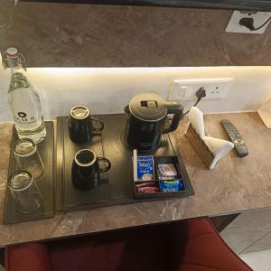 a tray with coffee pots and mugs on a table at Leaf 9 Imperial, Subhash Nagar, Pacific Mall in New Delhi