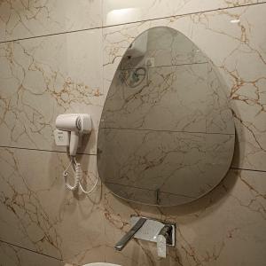 a mirror on the wall of a bathroom at Leaf 9 Imperial, Subhash Nagar, Pacific Mall in New Delhi +11 photos