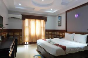 a bedroom with a bed with a teddy bear on it at Dara Panha Sak Guesthouse in Siem Reap