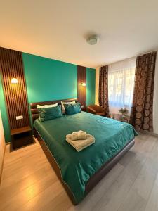 a bedroom with a green bed with a towel on it at Sunset Expanse in Turda