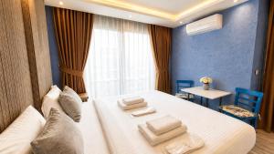 a bedroom with a white bed with towels on it at Teker Suite Hotel in Mersin