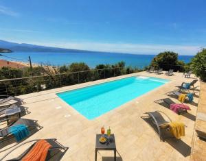 a swimming pool with chairs and a view of the ocean at Residence Arinella in Farinole