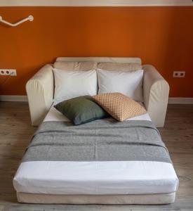 a couch with three pillows on it in a room at MG Suites & Infinity in Ravels +18 photos