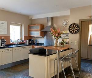 a kitchen with a island with a vase of flowers on it at MG Suites & Infinity in Ravels