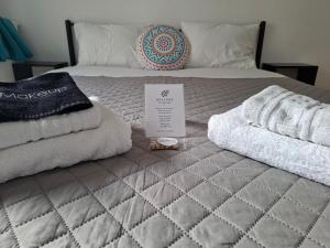 a bed with towels and a box on it at Hotel Liliana in Agia Marina Aegina